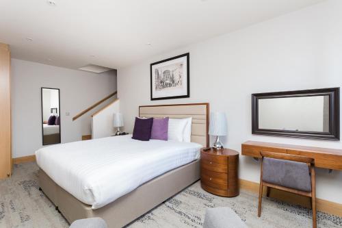 a bedroom with a bed and a desk and a computer at Sanctum Belsize Road in London