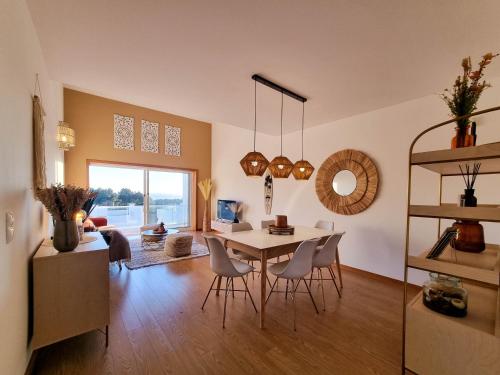 a dining room and living room with a table and chairs at Penthouse at Cabedelo Beach with Ocean View in Viana do Castelo