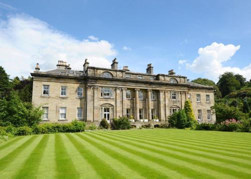 a large stone house with a large grassy yard at Balbirnie House Hotel in Glenrothes