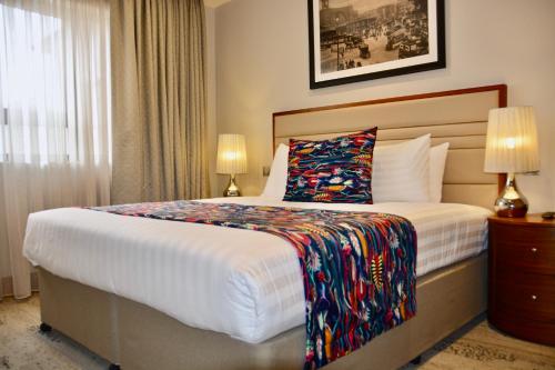 a bedroom with a large bed with a colorful blanket at Sanctum Belsize Road in London