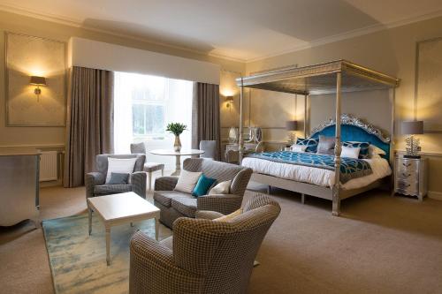 ein Schlafzimmer mit einem Himmelbett und ein Wohnzimmer in der Unterkunft Balbirnie House Hotel in Glenrothes