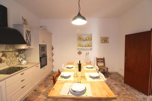 una cocina con una mesa de madera con platos. en CASA ANGELA, en Castiglion Fiorentino