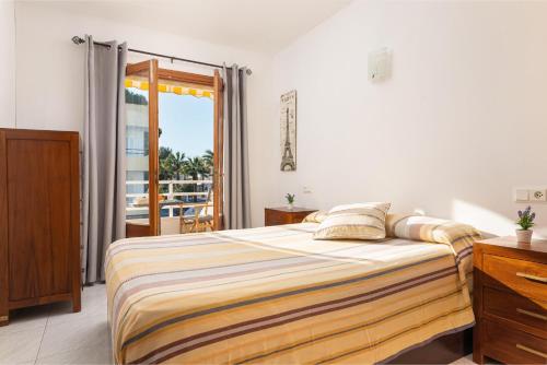 a bedroom with a bed and a balcony at Cimbell II in Playa de Muro