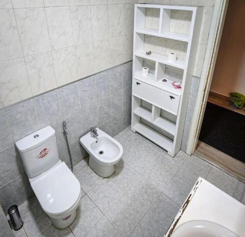 a bathroom with a toilet and a sink at 3BDR GREAT location, Spacious and family-friendly. in Umm Uthainah
