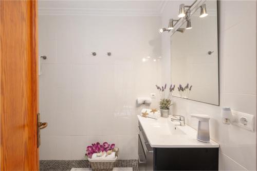 a white bathroom with a sink and a mirror at Cimbell II in Playa de Muro