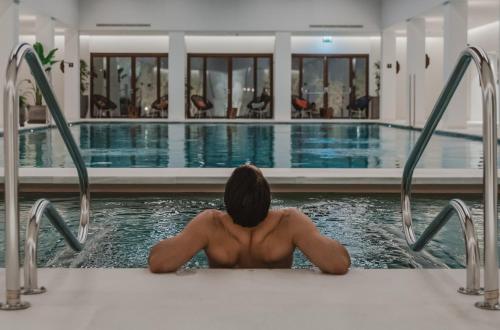 a man in a bath tub in a swimming pool at Kimpton Aysla Mallorca by IHG in Santa Ponsa