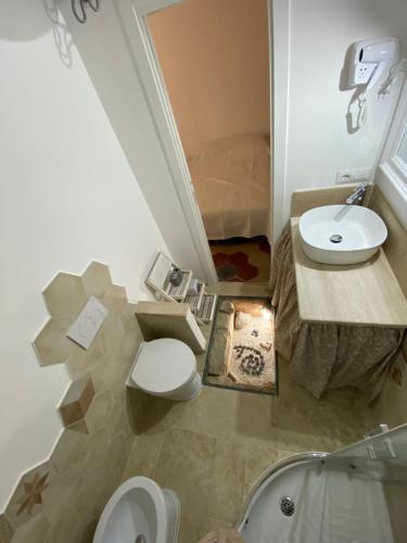 a bathroom with a toilet and a sink and a tub at Lu Bàtil B&B - Rooms in Alghero