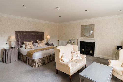 a hotel room with a bed and a fireplace at Balbirnie House Hotel in Glenrothes