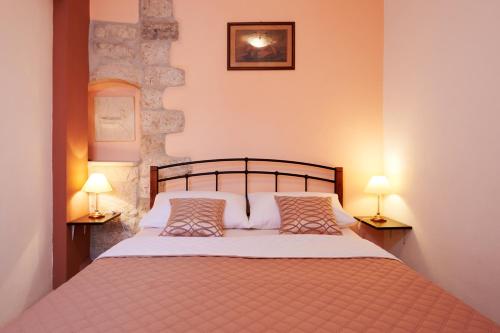 a bedroom with a large bed with two lamps at Apartments Ivica in Trogir