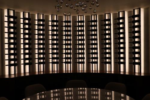 a dining room with a table and a wall of wine bottles at Sofitel Buenos Aires Recoleta in Buenos Aires
