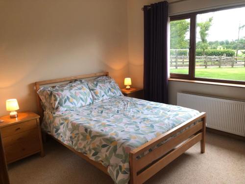 a bedroom with a bed and a window at Slemish View - a beautiful setting in countryside in Ballymena