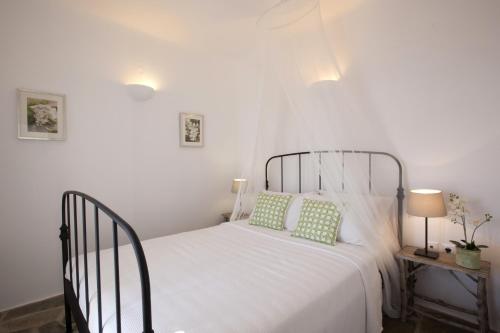 een slaapkamer met een wit bed met 2 kussens bij Kallisti Elia · Serene holiday villa - Views, nr Best family Beach in Naousa