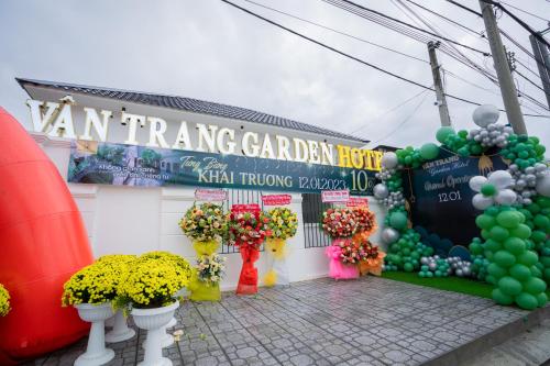 a building with a bunch of flowers and a sign at VÂN TRANG GARDEN HOTEL 2 in Vĩnh Long