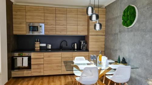 uma cozinha com uma mesa de jantar e cadeiras brancas em Apartmanica Double room apartment with balcony, St Ivan Rilski 4 star SPA Resort, Bansko em Bansko