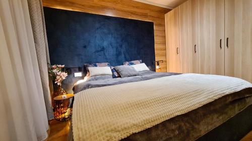 a bedroom with a large bed with a blue wall at Apartmanica Double room apartment with balcony, St Ivan Rilski 4 star SPA Resort, Bansko in Bansko