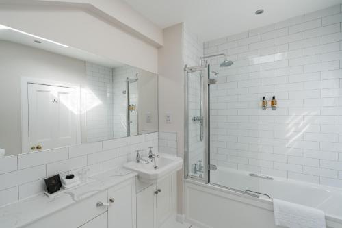 a white bathroom with a tub and a sink and a shower at Balbirnie House Hotel in Glenrothes