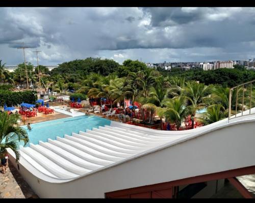 a view of a swimming pool with palm trees at APARTAMENTO SPAZZIO DI ROMA com acesso ao ACQUA PARK SPLASH in Caldas Novas