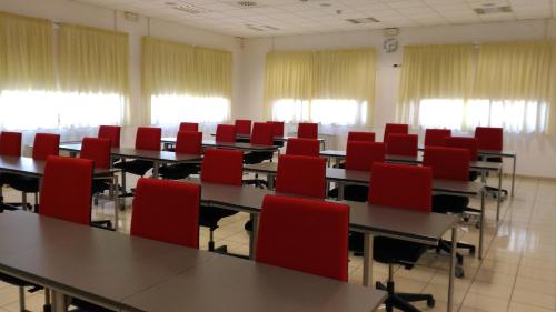 a room with tables and red chairs in it at Bed & Bike in Volterra