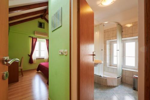 a room with a bathroom with a shower and a bedroom at Apartments Ivica in Trogir