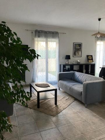 un salon avec un canapé et une table dans l'établissement Charmante villa dans un lotissement très calme, à Béziers