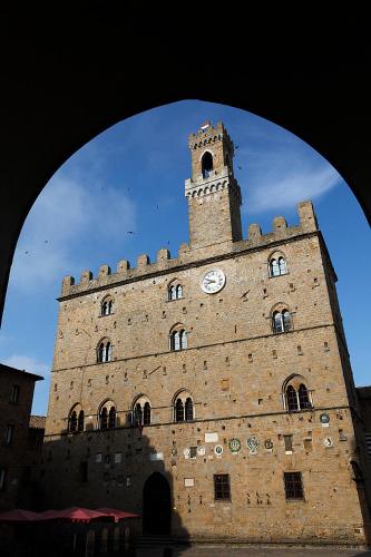 a large brick building with a clock tower on it at Bed & Bike in Volterra