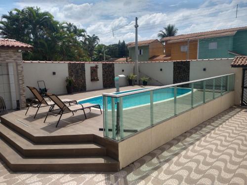 balcone con piscina e 2 sedie di Piscina aquecida, 3 dorms ar condicionado, Cervejeira e Bilhar, a 500 metros do Mar a Bertioga