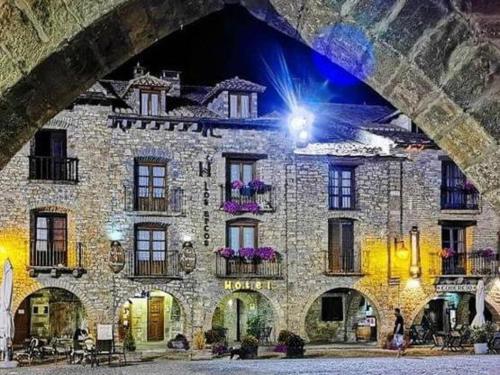 un gran edificio de piedra con una luz en él en Los Arcos, en Aínsa