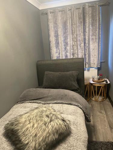 a bedroom with a bed with a blanket and a window at Da Vinci Guest House & Guest Parking, A Real Gem in Crawley