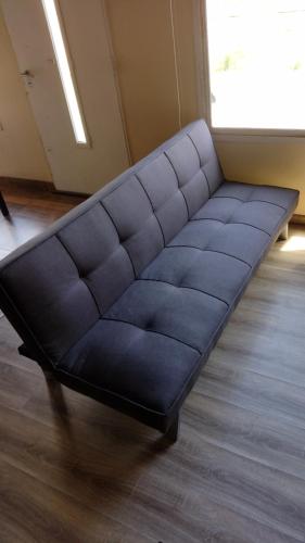 a black couch sitting on the floor in a room at Laguna de los Cisnes in Perito Moreno