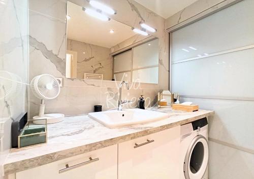 une salle de bain avec un lavabo et une machine à laver dans l'établissement Viva Riviera Luxury 2 Bedrooms Residence les Tuileries, à Cannes