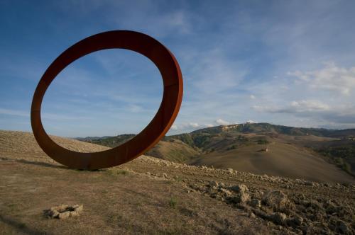 a large wooden sculpture in the middle of a field at Bed & Bike in Volterra