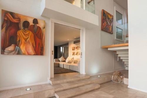 a living room with a painting on the wall at Benguela Cove - Oceans Away in Hermanus