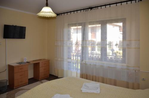 Schlafzimmer mit einem Bett und einem Fenster in der Unterkunft Apartmani Janja in Sokobanja