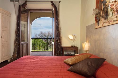 1 dormitorio con cama roja y puerta abierta en CASA GIOVANNA, en Castel San Gimignano