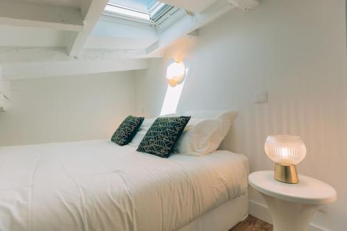 - un lit blanc avec des oreillers et une lampe sur une table dans l'établissement #32 Panoramic Sea View over Old Town Terrace & AC, à Nice