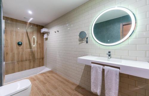 a bathroom with a sink and a shower and a mirror at DWO Nopal in Puerto de la Cruz