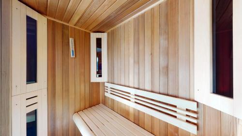 a wooden bench in a sauna with two windows at Etoiles des Neiges LUXE & JACUZZI chalet 12 pers by Alpvision Résidences in Hérémence