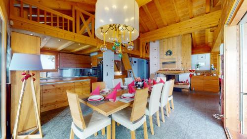 a dining room with a wooden table and chairs at Etoiles des Neiges LUXE & JACUZZI chalet 12 pers by Alpvision Résidences in Hérémence