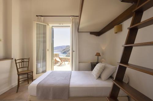 een slaapkamer met een bed en uitzicht op de oceaan bij Seaview Beach House in Ándros