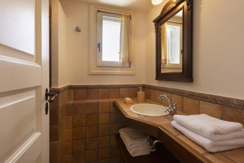een badkamer met een wastafel en een spiegel bij Seaview Beach House in Ándros