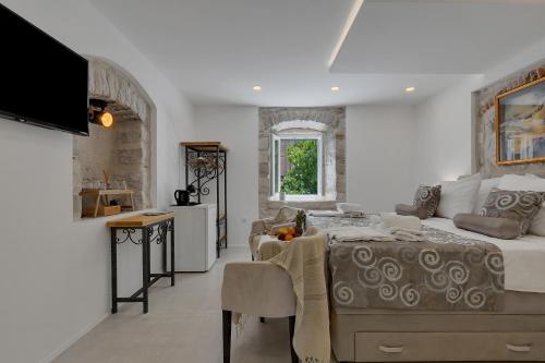 a bedroom with a bed and a table and a kitchen at Luxury Rooms Palace B&B in Makarska