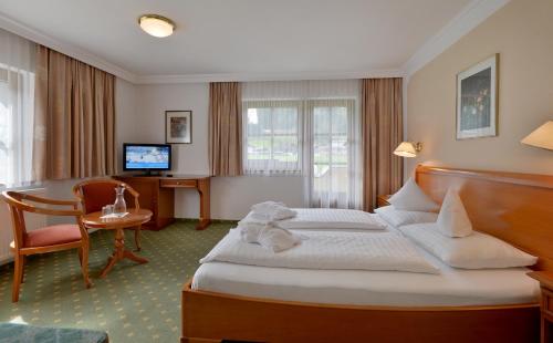 マイヤーホーフェンにあるHotel Waldheim Garniのベッドとデスクが備わるホテルルームです。