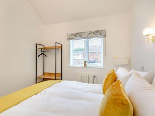a bedroom with a white bed with pillows and a window at Uk39735 - Bay Cottage 2 in North Somercotes