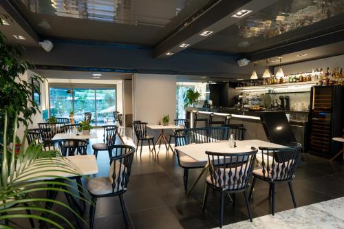 un restaurante con mesas y sillas y un bar en Garden City Resort, en Kalamata