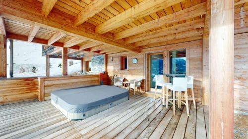 a room with a bed on a wooden deck at Etoiles des Neiges LUXE & JACUZZI chalet 12 pers by Alpvision Résidences in Hérémence