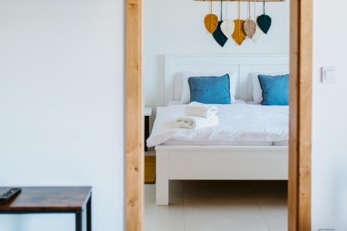 a bedroom with a white bed with blue pillows at Pod humnama in Krumvíř