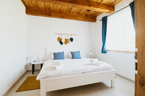 a white bedroom with a bed and a desk at Pod humnama in Krumvíř