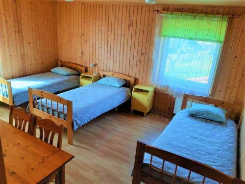 a room with two beds and a table and a table at Tuhala Jarve Talu in Tuhala