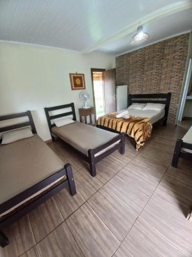 聖喬治的住宿－Chalés Ocaso，一间设有两张床和砖墙的房间