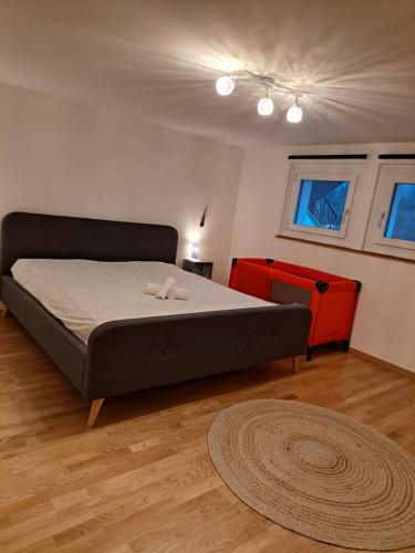 1 dormitorio con 1 cama y vestidor rojo en Appartement lumineux et spacieux à Charmey - Coin de paradis, en Charmey
